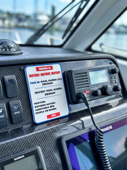 Marine radio console with a mayday sign on a boat dashboard